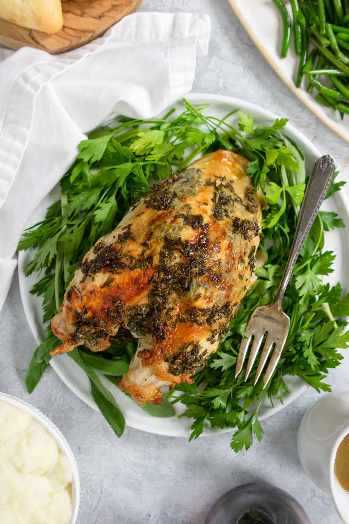 oven roasted turkey breast on a plate with herbs