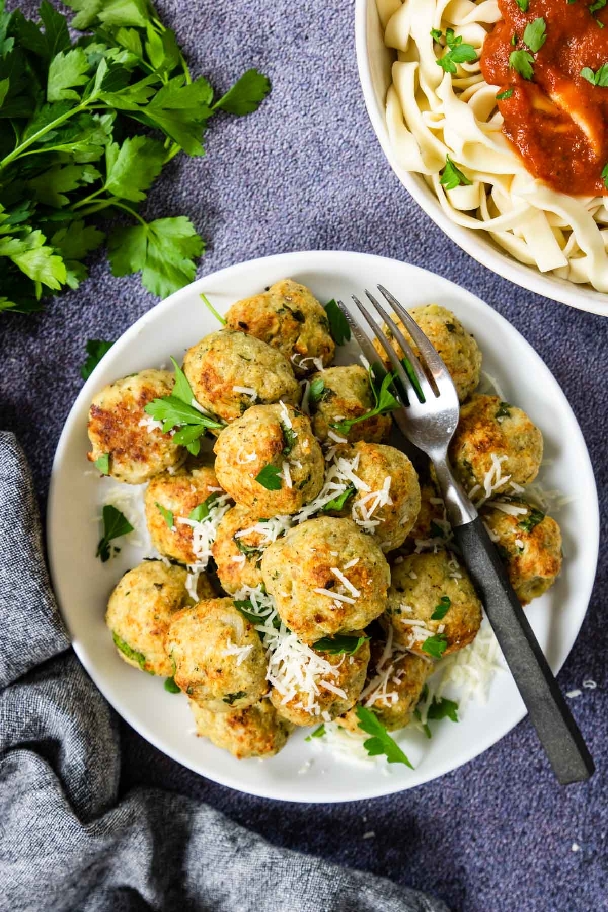 A pile of baked chicken meatballs with spaghetti