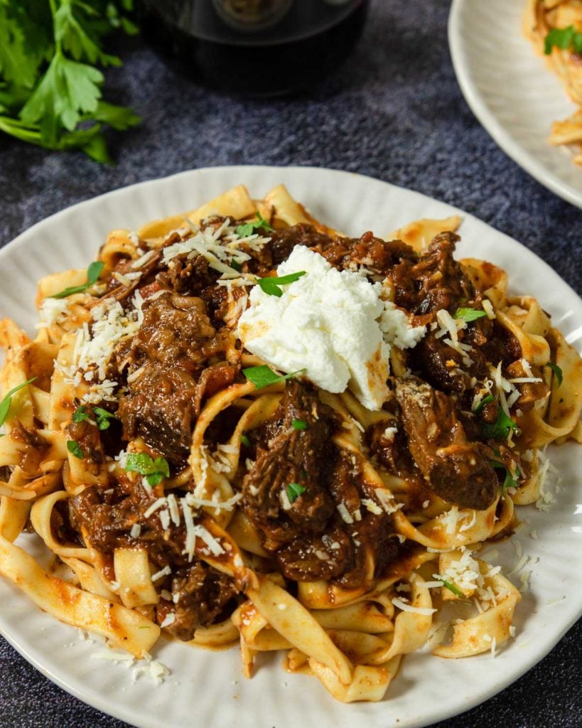 tagliatelle pasta topped with beef ragu and a dollop of ricotta cheese