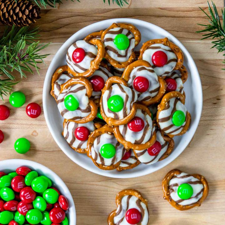 Christmas hug cookies on a plate with evergreen to the side