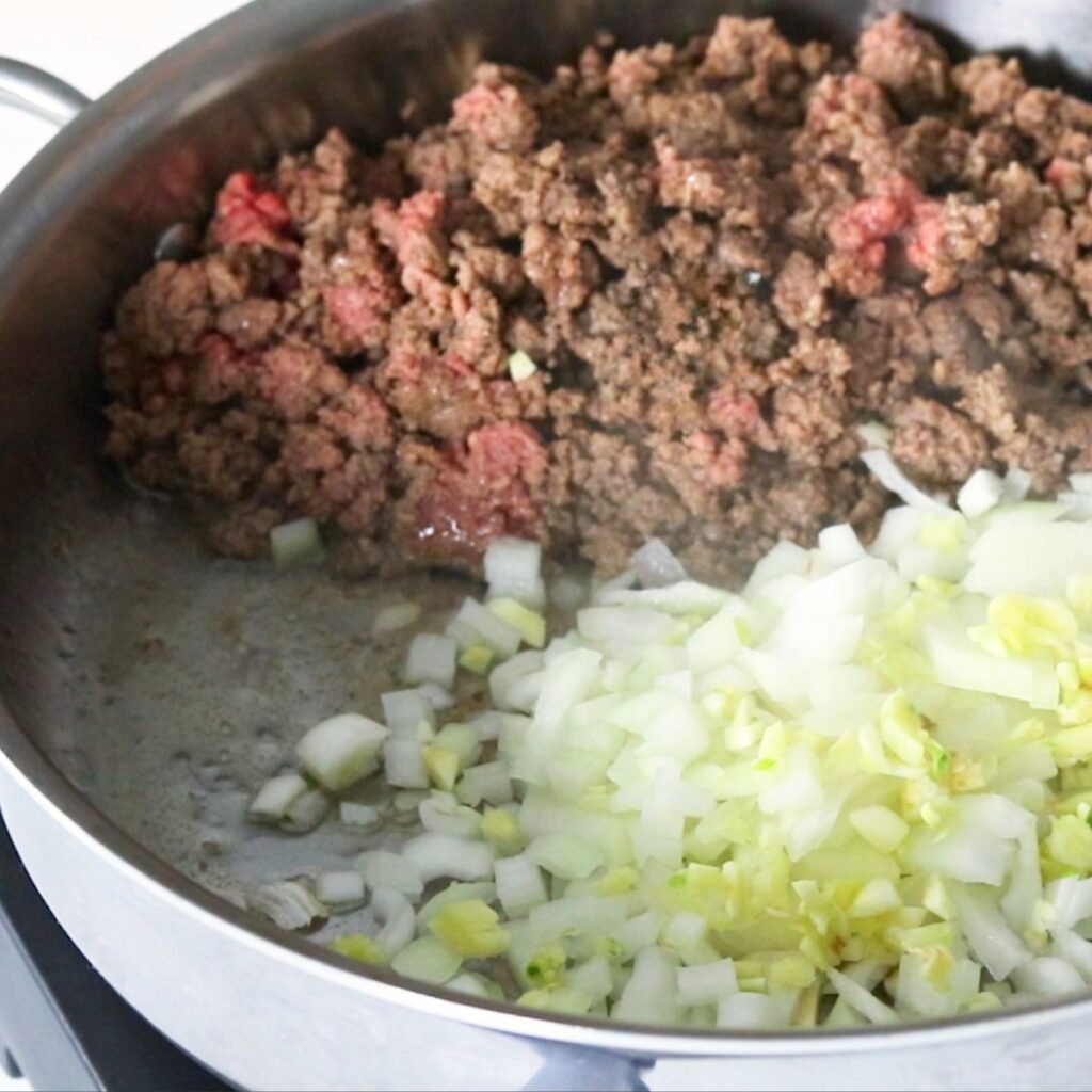 Adding onions to the pan with ground beef 