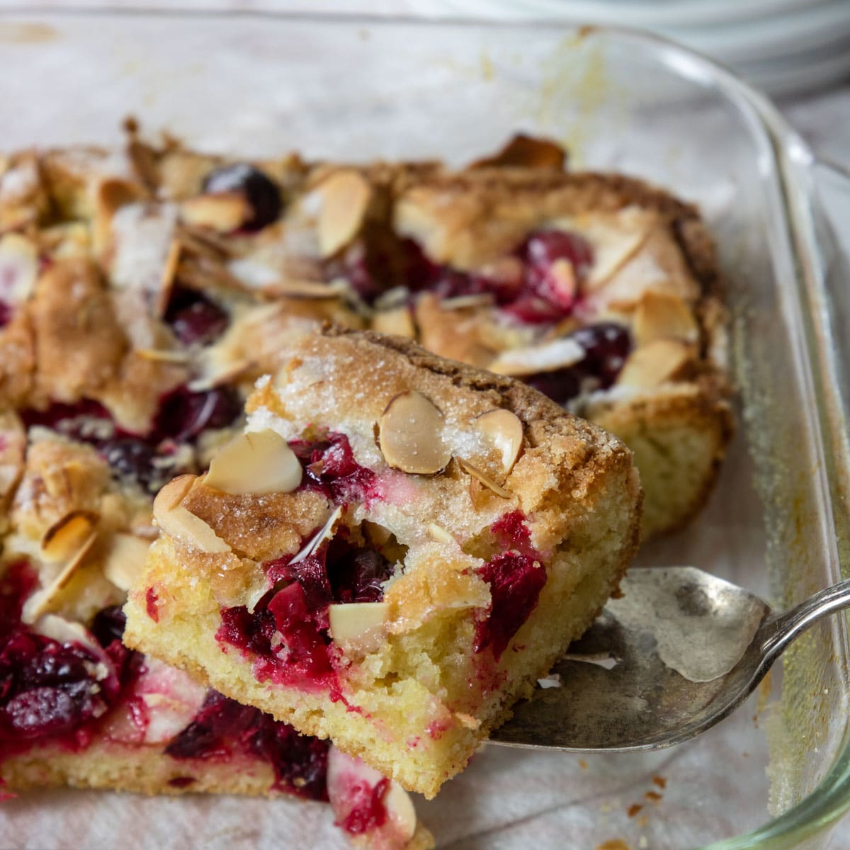 a slice of cranberry almond cake on a serving spoon