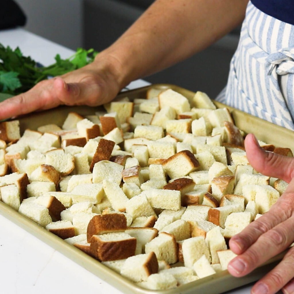 a baking sheet full of stale bread cubes 