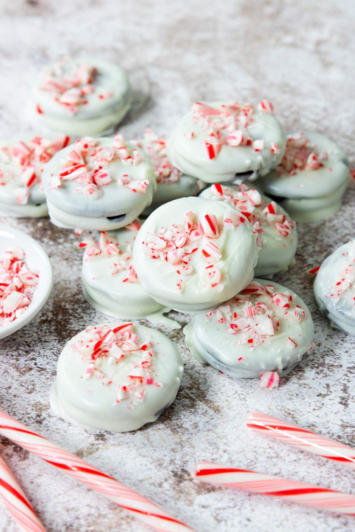 homemade white chocolate covered candy cane oreos laid out in a pile