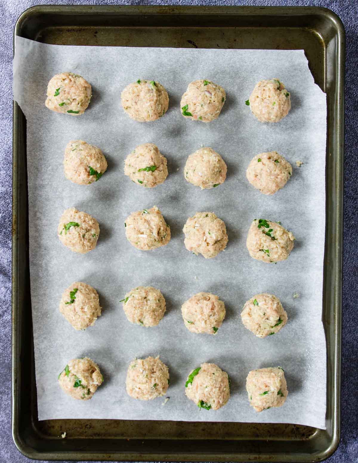 a tray of rolled chicken meatballs that are raw