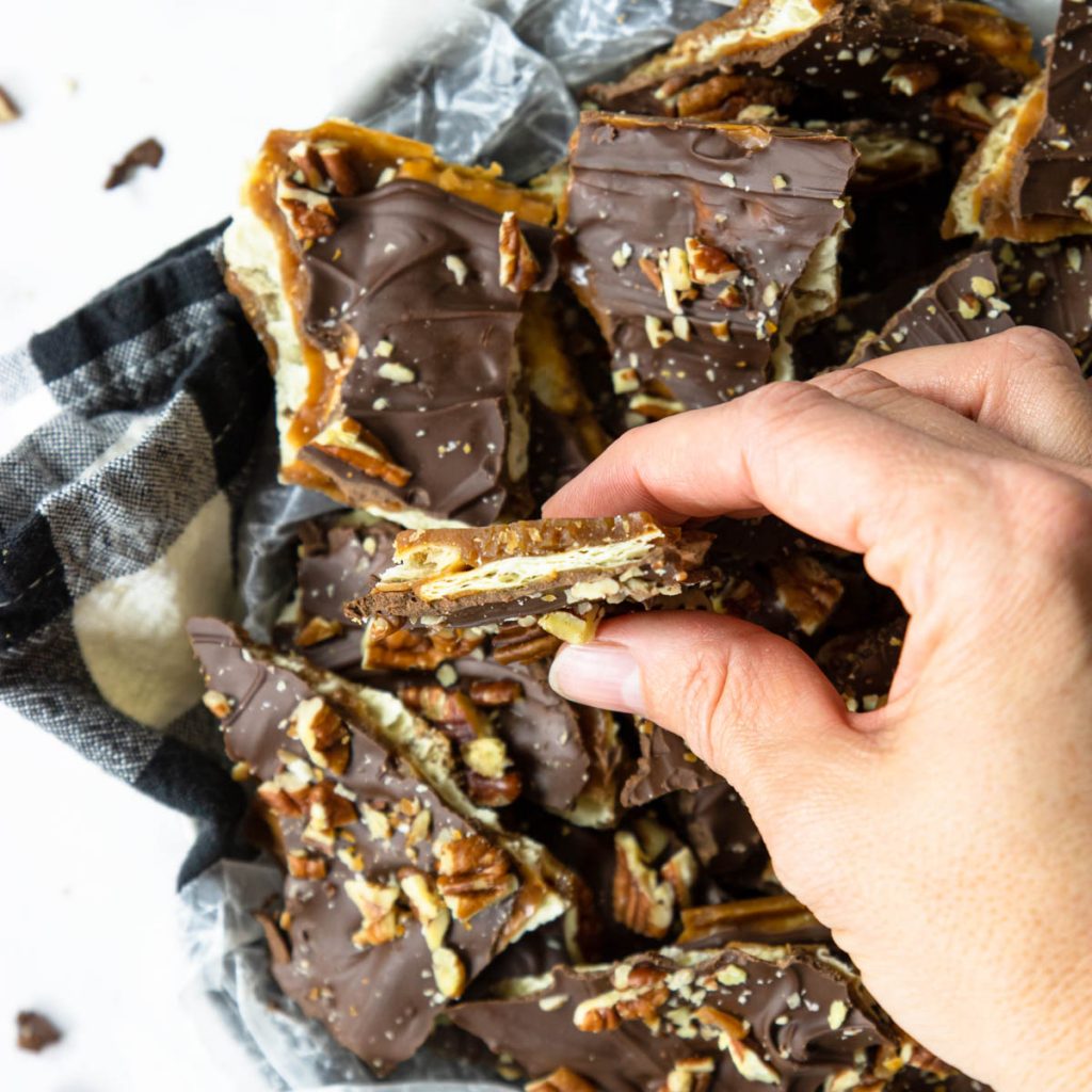 Fools toffee broken in half being held in a hand 