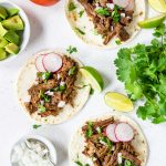 Mexican Shredded Beef on flour tortillas with white onions, cilantro and lime wedges