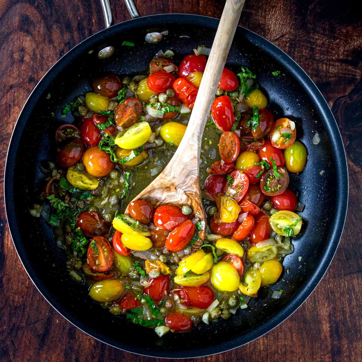 sauteed tomatoes, garlic, shallots and capers in a pan