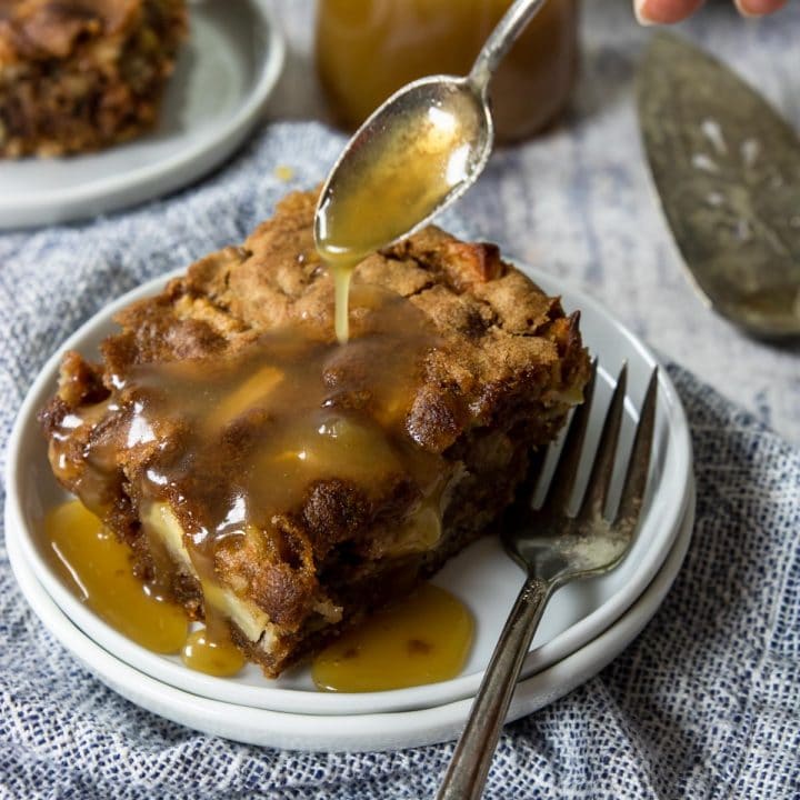 a piece of apple spice cake with sauce drizzled over the top