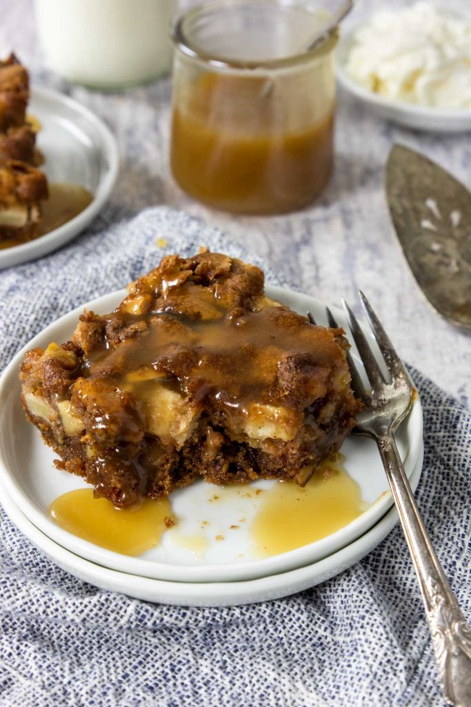 Apple spice cake with butter rum sauce being drizzled over the top