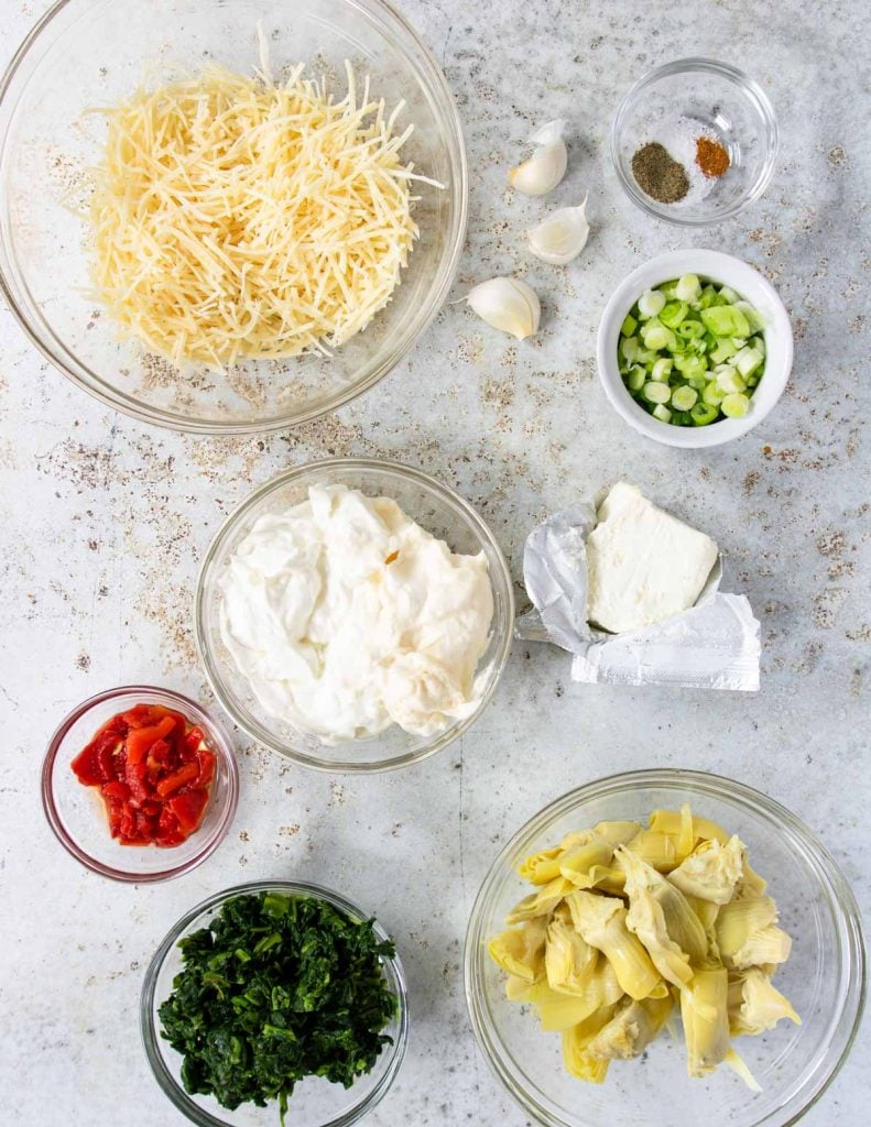 ingredients for spinach artichoke dip laid out on a table