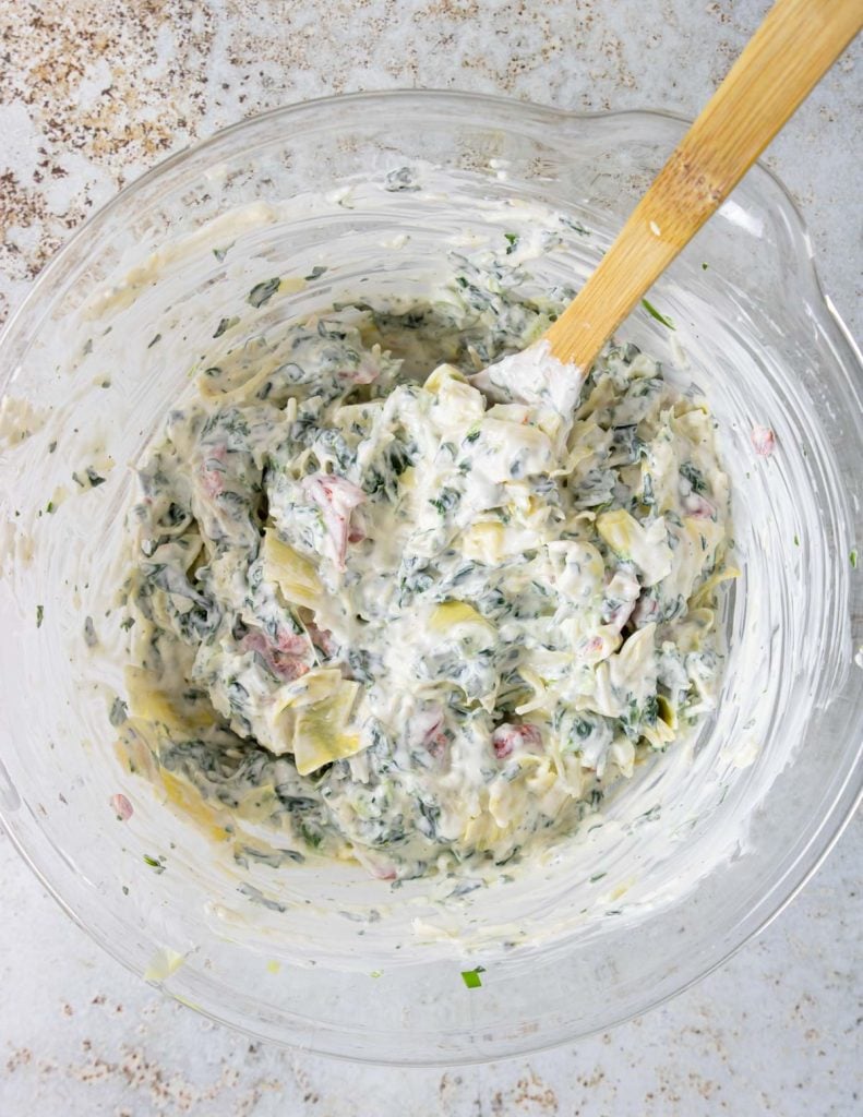 spinach artichoke dip mixture in a bowl before it gets baked