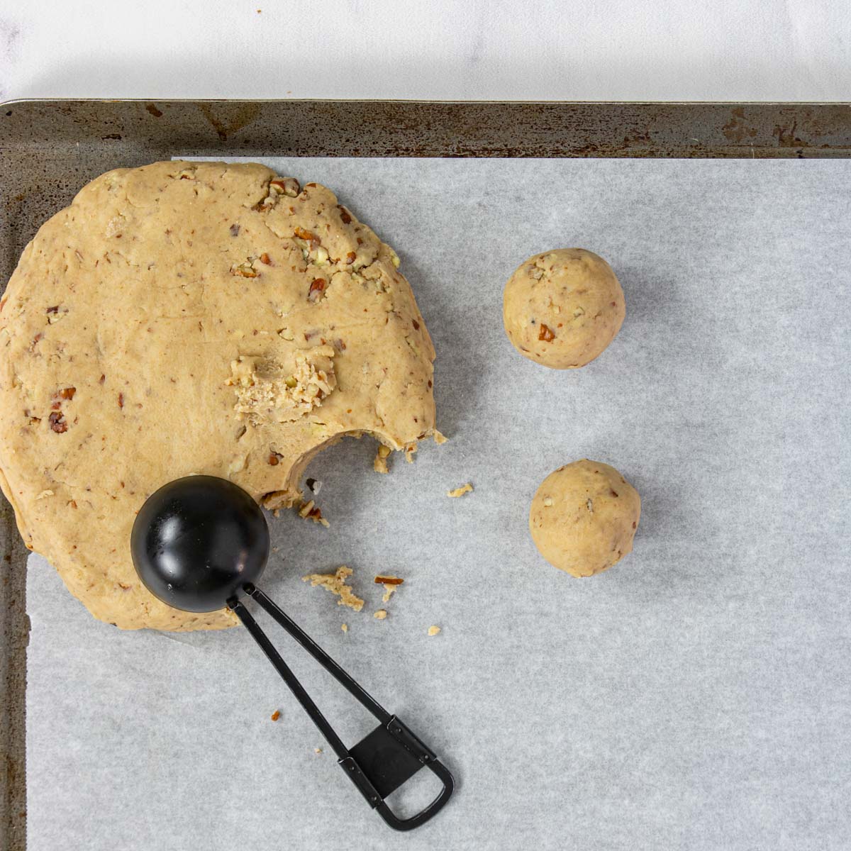 pecan snowball cookie dough and a tablespoon scoop