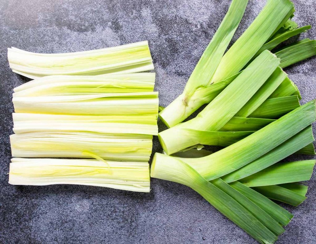 a leek with the root and stem cut and then split in half