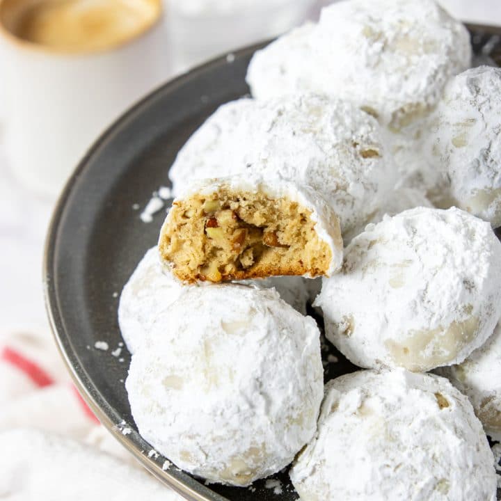 a pecan snowball cookie that is broken in half to see the middle