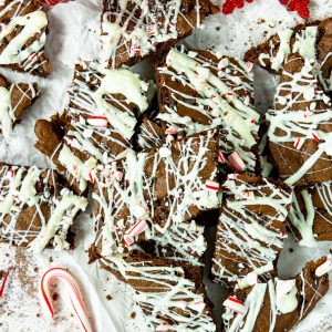 a pile of peppermint brownie brittle drizzled with white chocolate and crushed candy canes