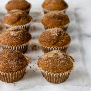 cinnamon and sugar topped muffins on a table