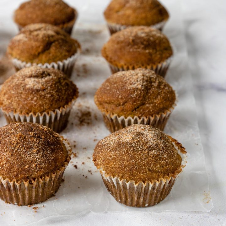 cinnamon and sugar topped muffins on a table