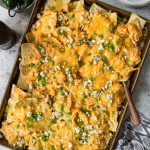 a tray of buffalo chicken nachos topped with green onions