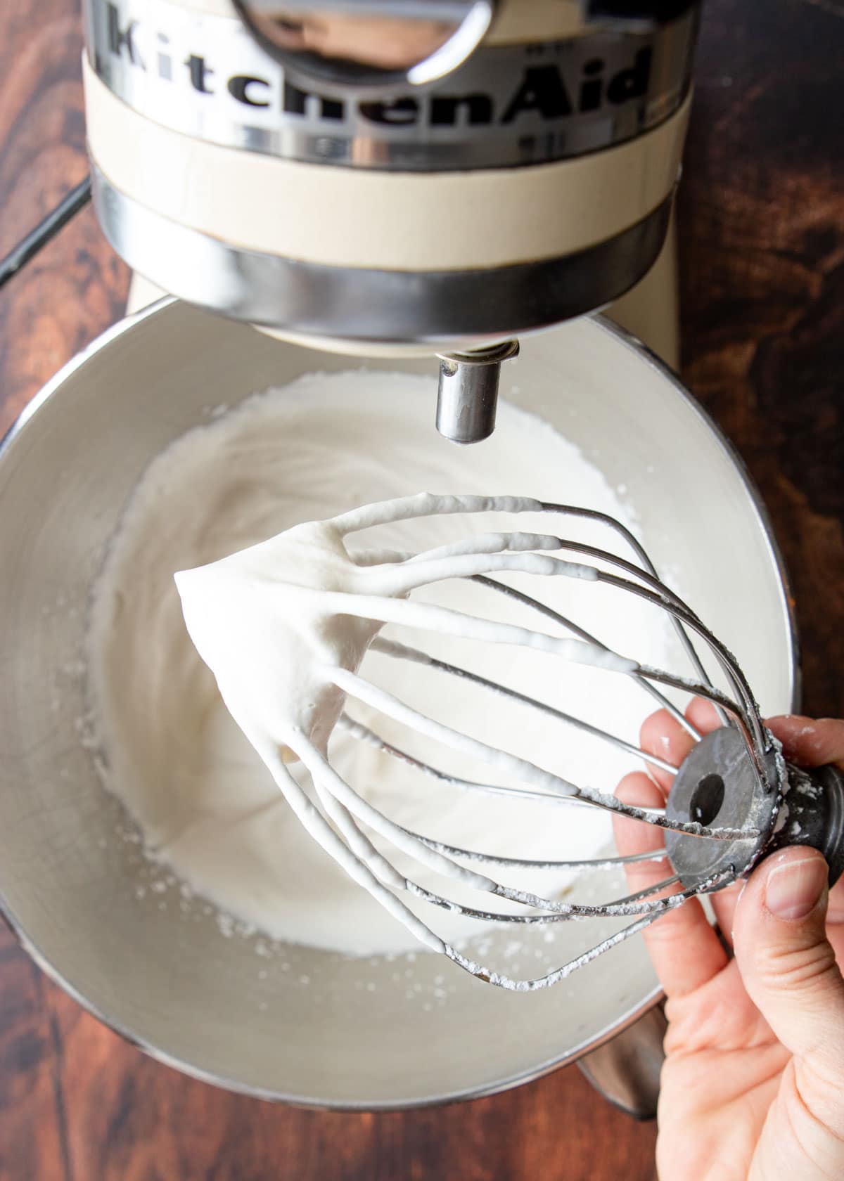 a whisk with whipped cream on the tip
