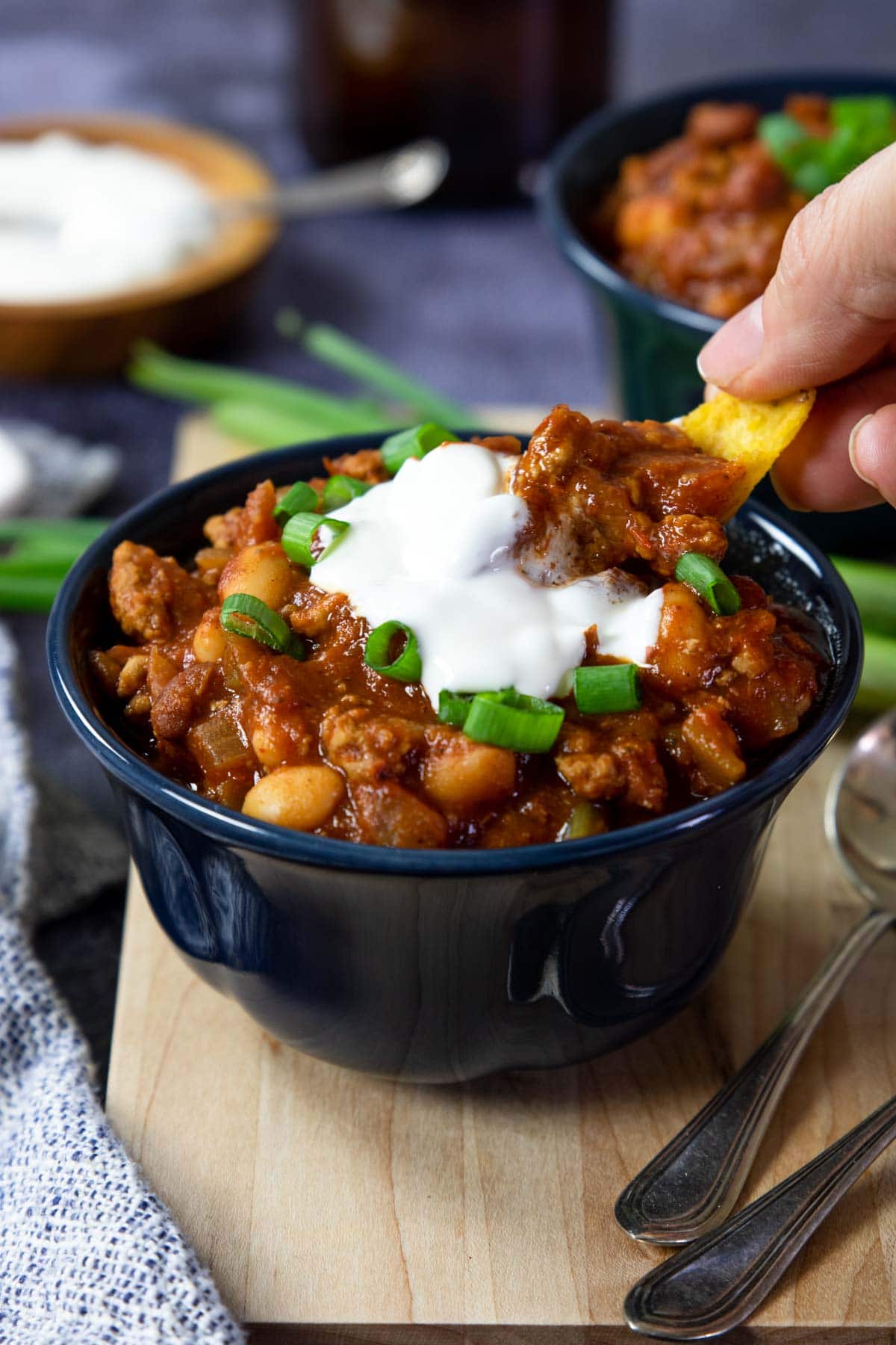 Ground turkey chili in a bowl with sour cream and green onions