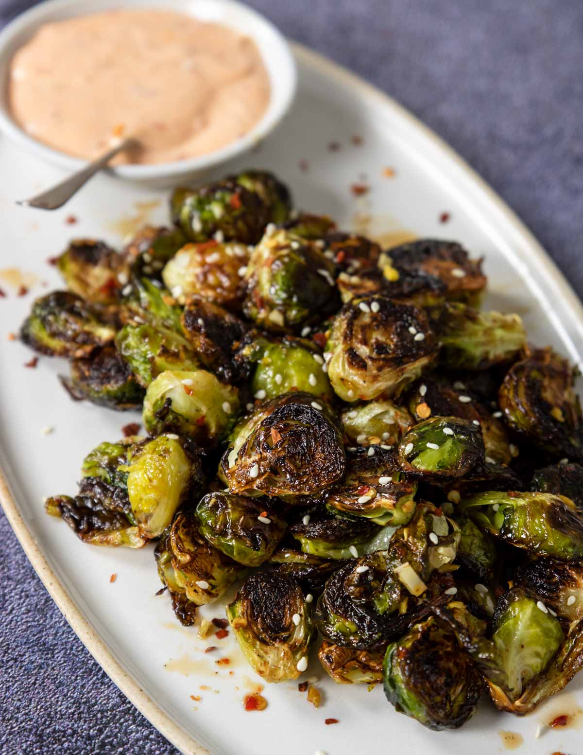 roasted brussels sprouts on a plate with a dipping sauce