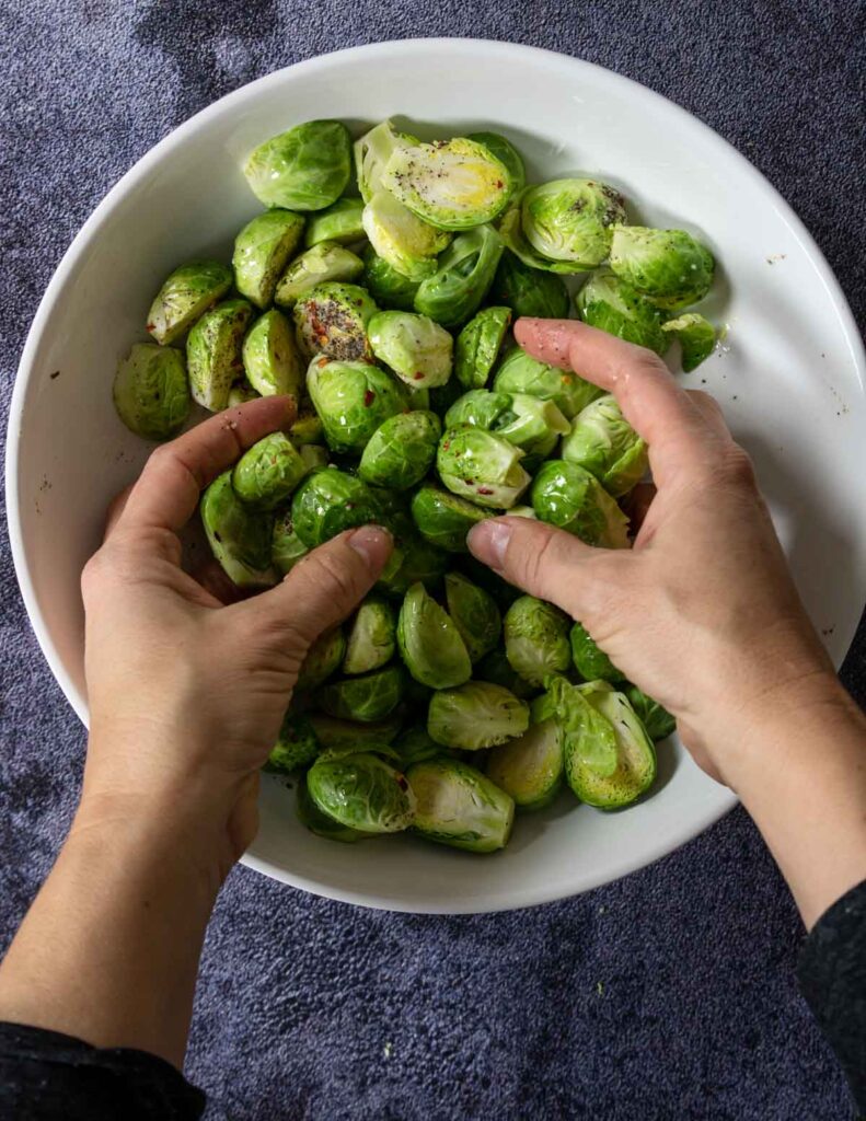 tossing prepped brussels sprouts in oil