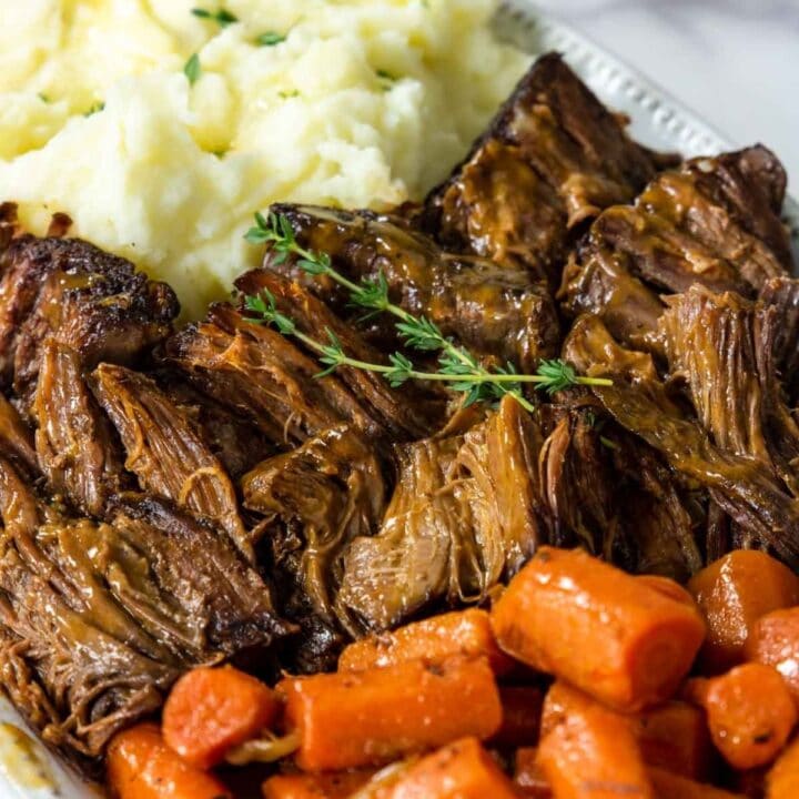 a platter of pot roast carrots and mashed potatoes