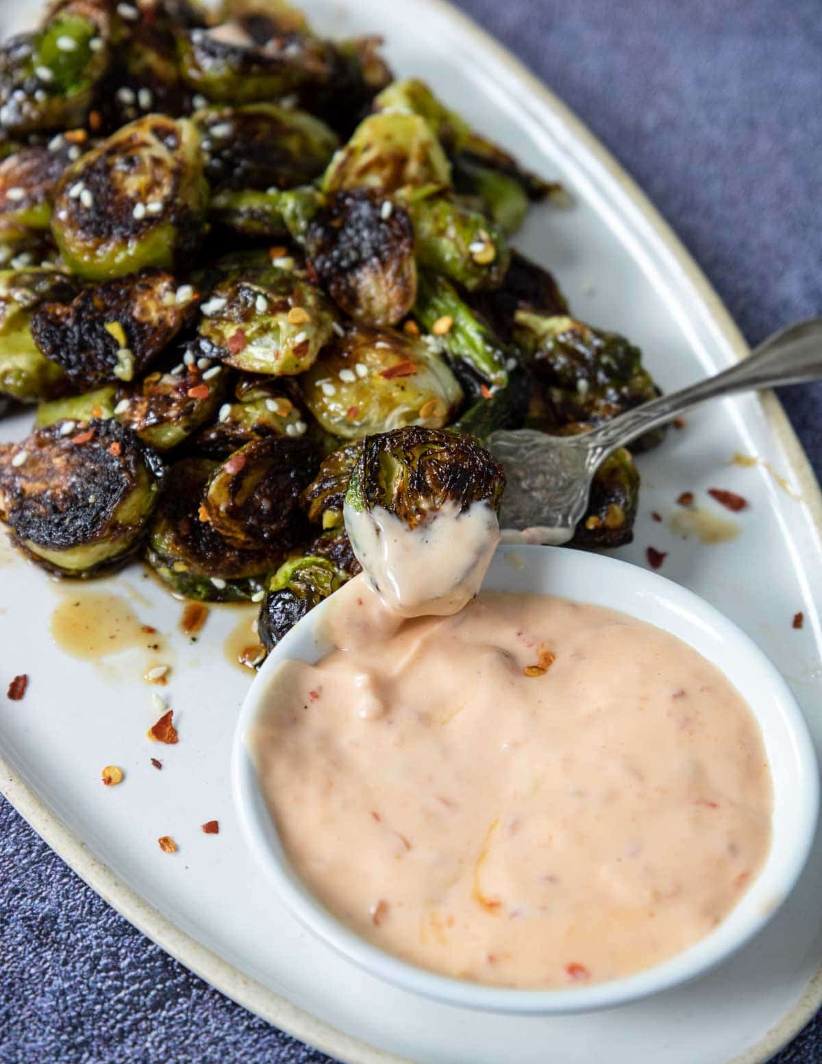 Asian Brussels Sprouts being dipped in Sambal Aioli