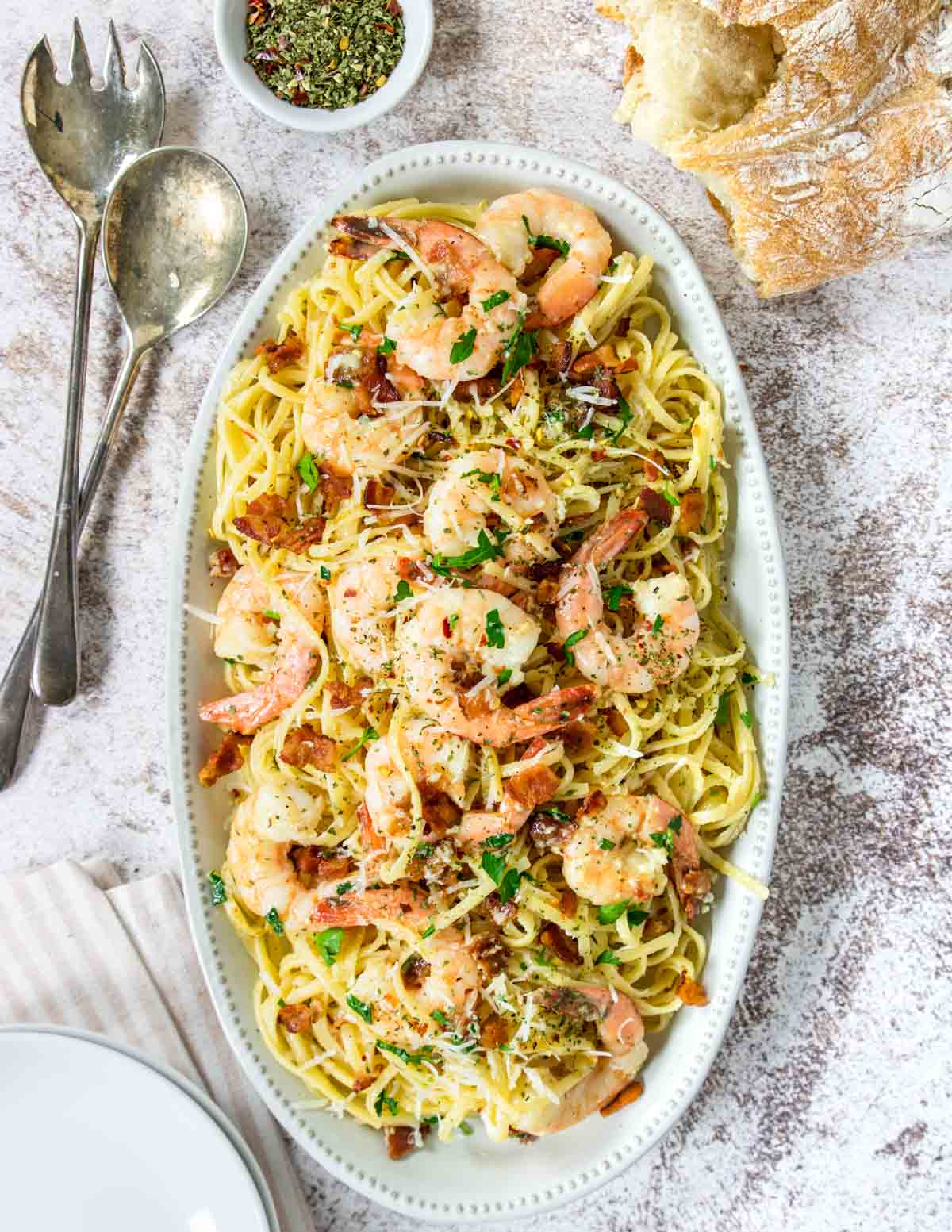 Shrimp and pasta on a serving platter with parsley and parmesan