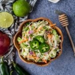 a bowl of cilantro lime slaw topped with jalapenos