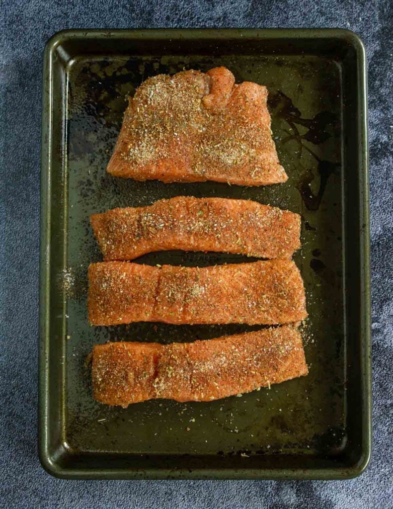 raw salmon filets on a baking sheet