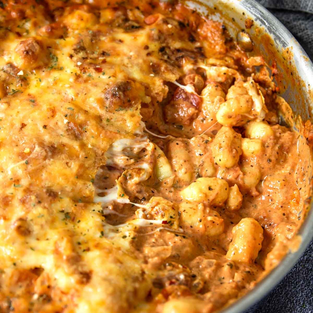 gnocchi bake in an oven safe skillet with a serving taken out of the pan