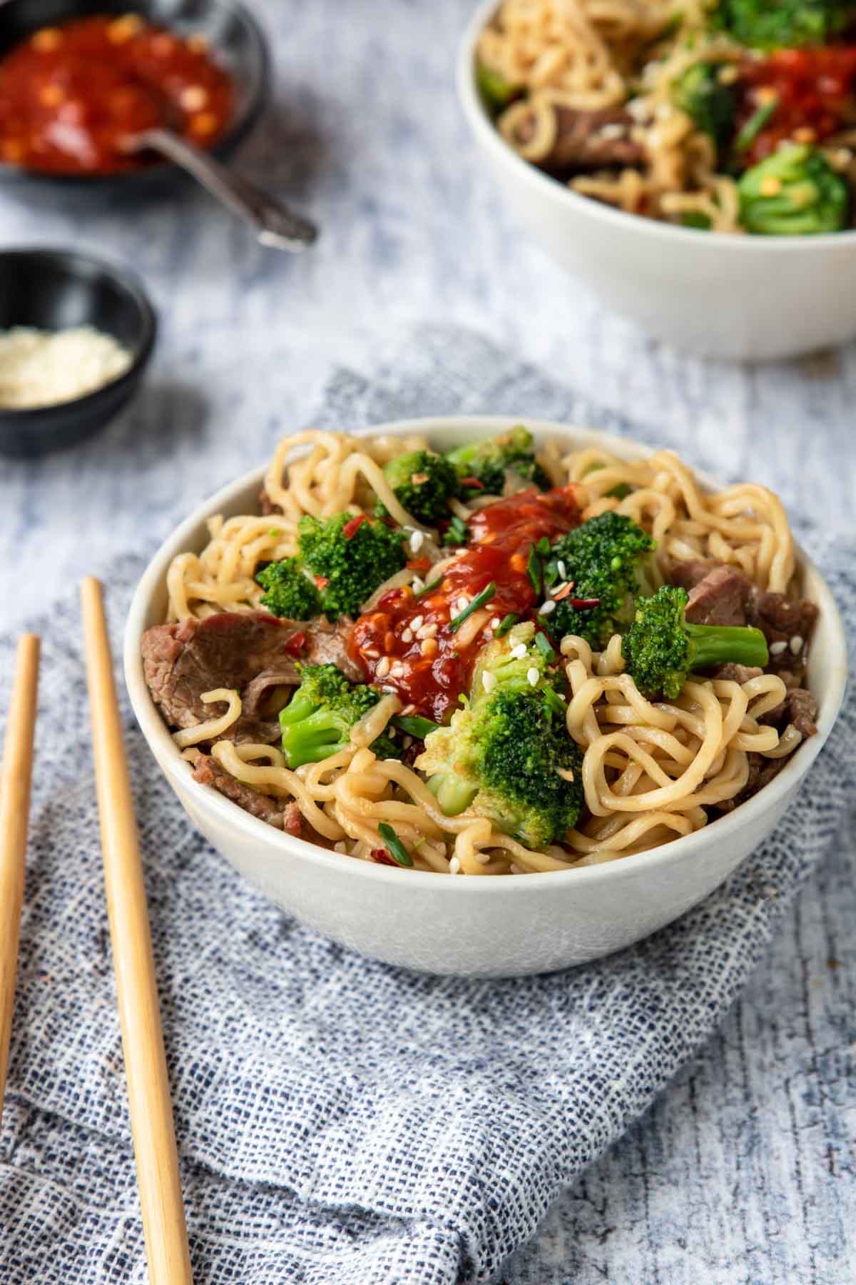 a bowls of ramen noodles with broccoli and beef