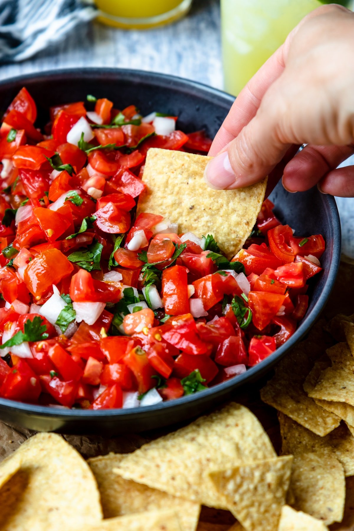 pico de gallo with a tortilla chip dipping in