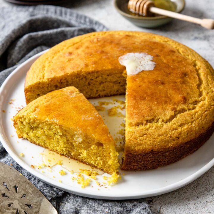 cornbread with a sliced turned to the side and covered in honey