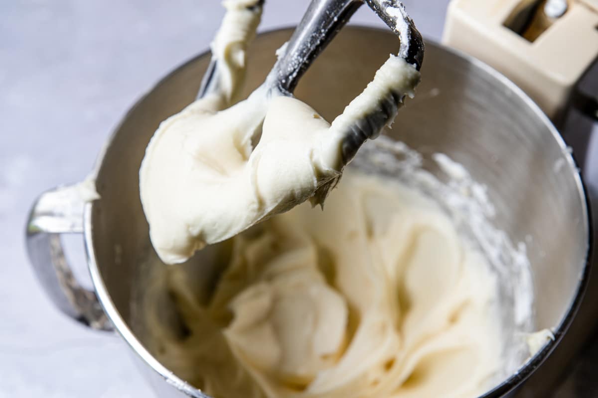 cream cheese icing on a beater of a stand mixer