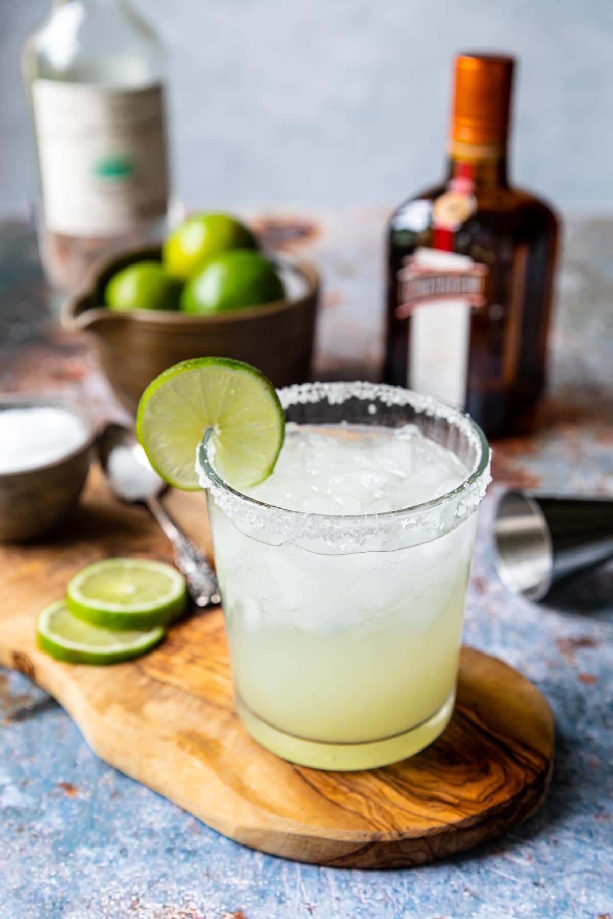 a classic margarita in a rocks glass with a salt rim and a lime wheel