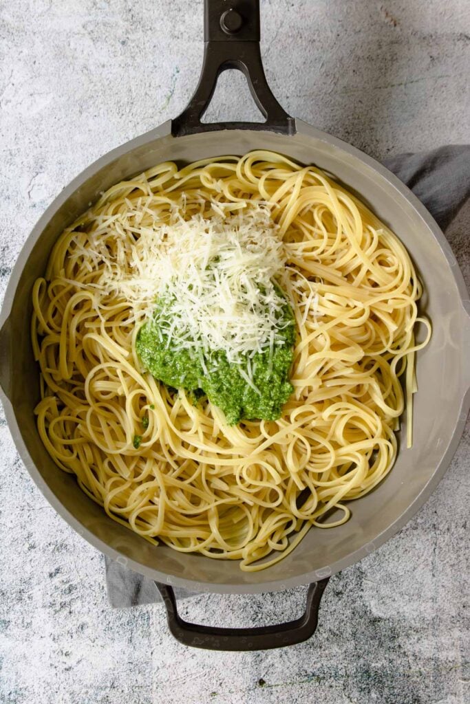 cooked pasta topped with pesto and parmesan
