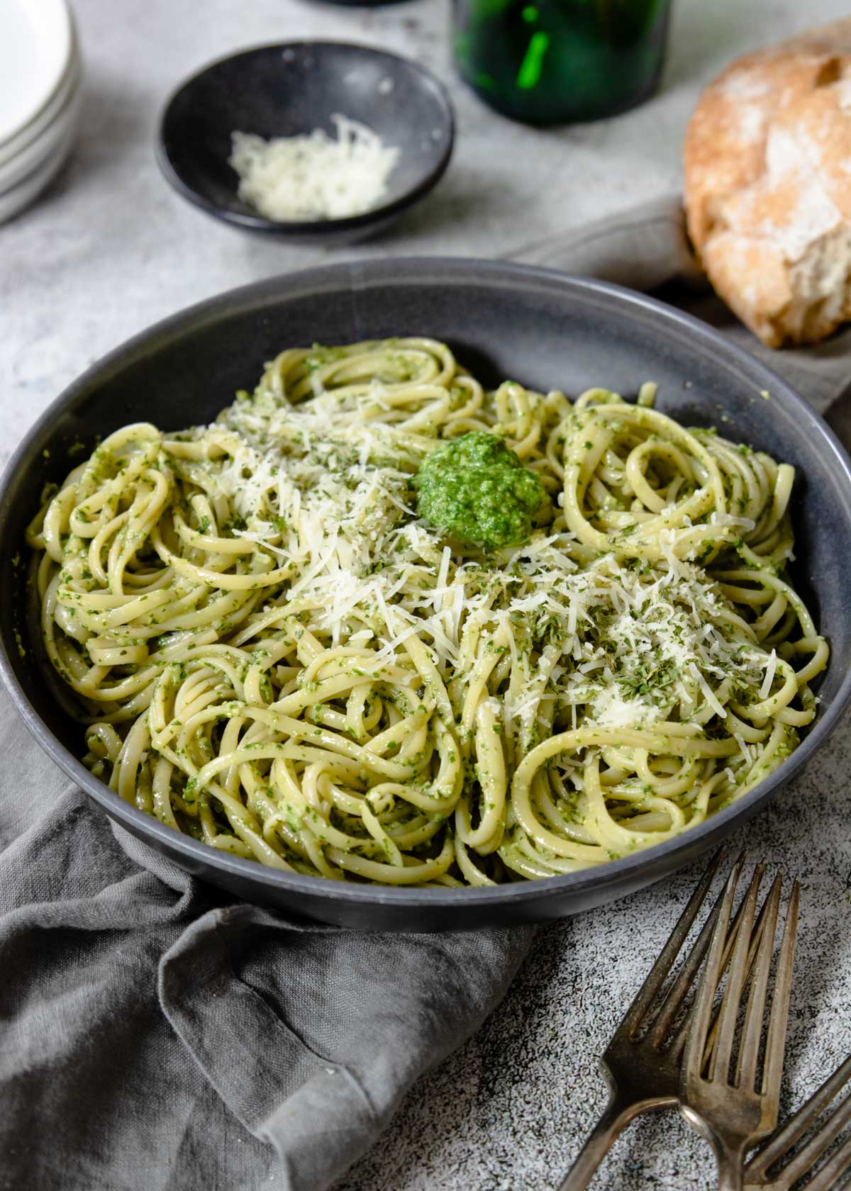 a big bowl of pesto pasta topped with parm cheese