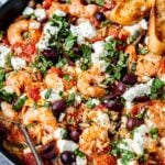 close up of Mediterranean shrimp in a skillet topped with feta cheese