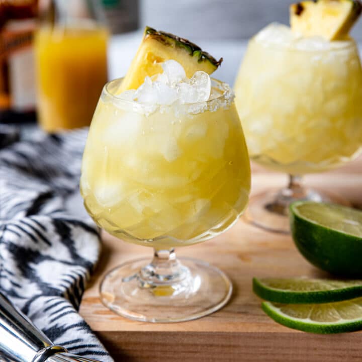 pineapple margarita in an etched glass, garnished with a pineapple wedge