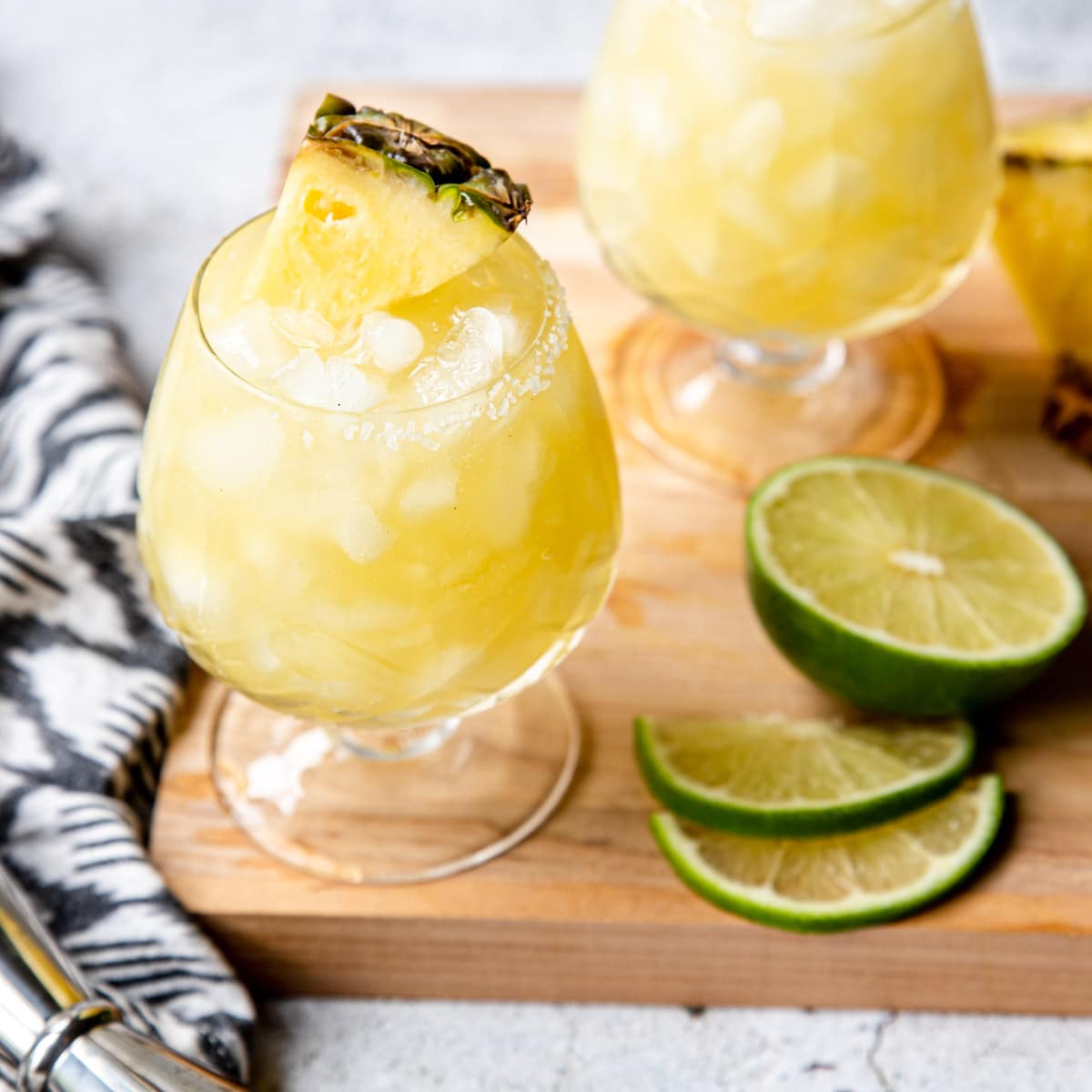 two pineapple margaritas on a table