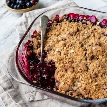 a pan of blueberry crumble with a spoonful taken out.