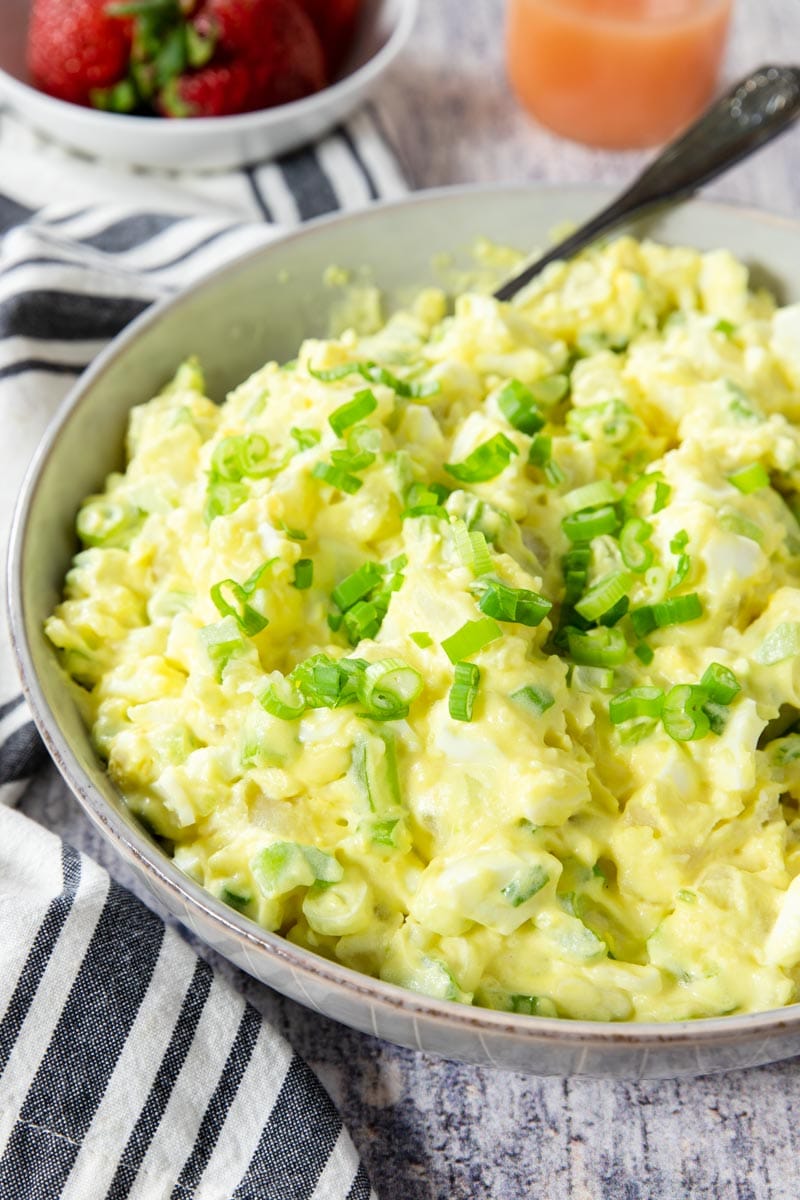 potato salad with egg in a bowl garnished with green onions