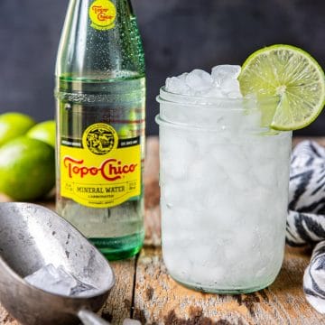 ranch Water cocktail in a mason jar with a bottle of Topo Chico