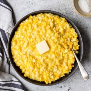 creamed corn in a serving bowl with a pat of butter