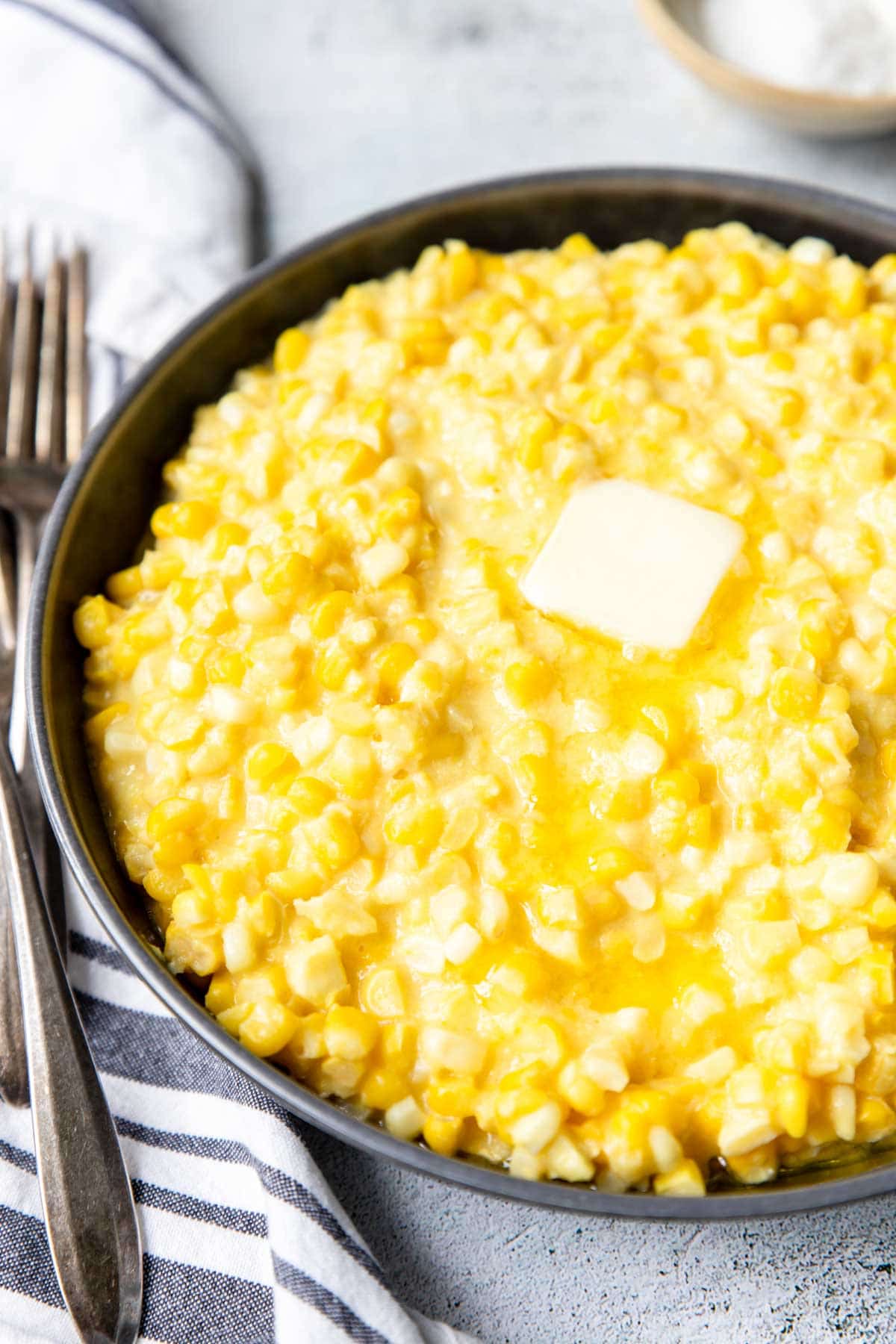 creamed corn in a pan with butter on top