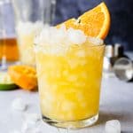 an orange margarita in a glass with an orange wedge