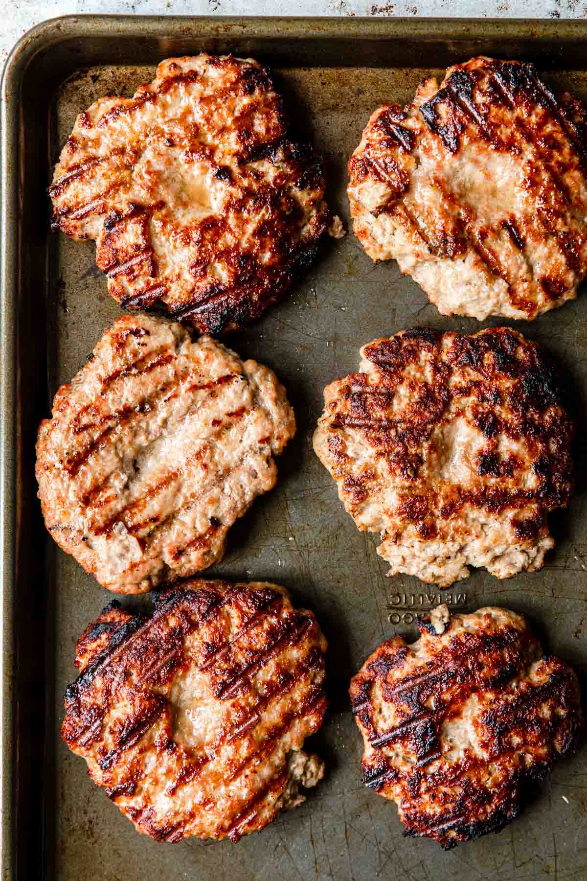 grilled pork burgers on a tray